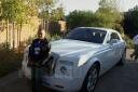 Photo of (Rick Ross Son) posing in front Floyd Mayweather Jr. Bentley