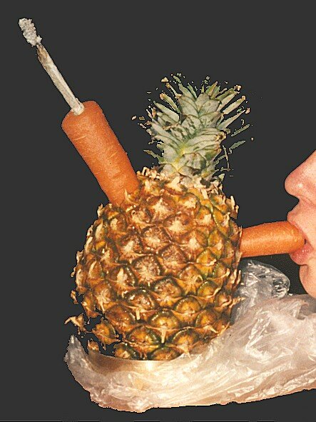 Someone Smoking a Joint out of Pineapple bong