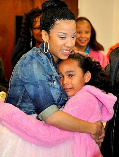 Picture of Keyshia Cole pregnant hugging a child at ActsFullGospel Church