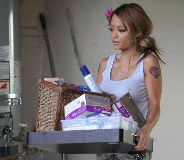 Picture of Tila Tequila carrying the late Casey Johnson personal affects away